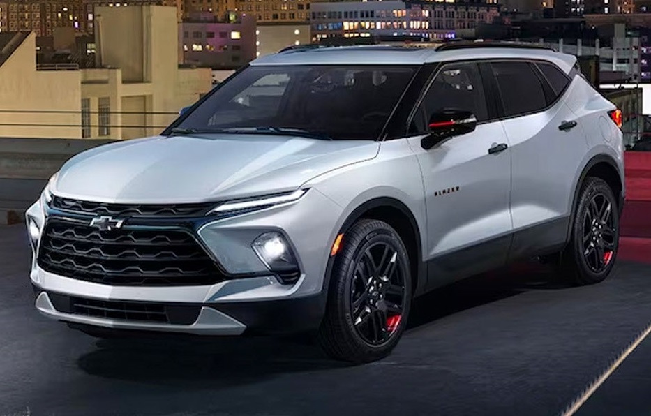 An image of a silver 2024 Chevy Blazer sitting on a rooftop parking pad with an image of the city behind it.
