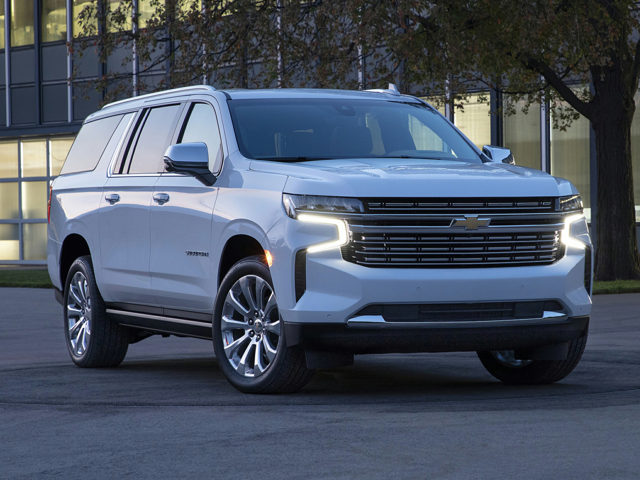 A white Chevrolet Suburban parked outside near a building