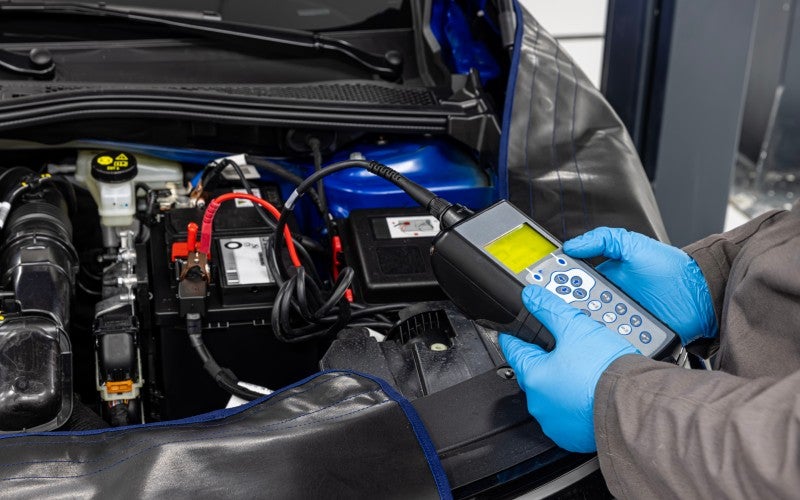 Technician testing car battery near Redwood Falls, MN